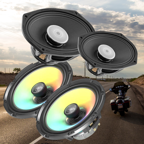 Four black speakers, two with rainbow-colored cones, are superimposed over a scenic road with a motorcycle parked on the right side under a partly cloudy sky.