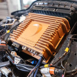 A gold-colored Diamond Audio amplifier is installed among various wires and electronic components inside a vehicle, seamlessly integrating with the Diamond Audio 2014-2023 Plug N-Play Digital Media Receiver for Harley Davidson® Touring Motorcycles (MSHD14) for enhanced connectivity.