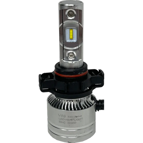 Close-up of a LUMI Stage 2 5202 LED Headlight Bulb by Lumi, featuring a silver body with cooling fins, a black plastic base, and a yellow CSP chip. The label reads V8S LED Headlight EMC 2020D. This high-performance bulb is equipped with advanced CSP chips that provide bright 6000K illumination. The background is plain white.