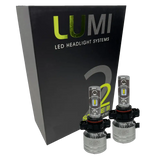 Two LUMI Stage 2 5202 LED Headlight Bulbs from Lumi are shown in front of a black box labeled “LUMI LED Headlight Systems Stage II Smart Kit” on a plain background, delivering powerful 6000K illumination.