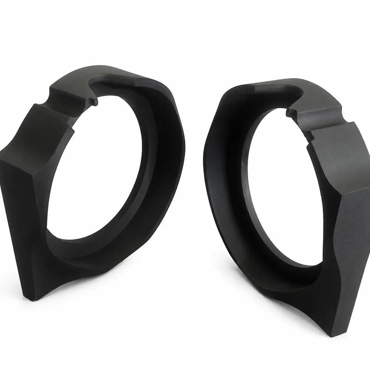 Two black, geometric, ring-shaped objects with angular edges—Nagy’s Customs Harley Davidson 8″ Sub / MidBass Mounts (1998-Present)—are positioned upright on a white surface, facing each other.