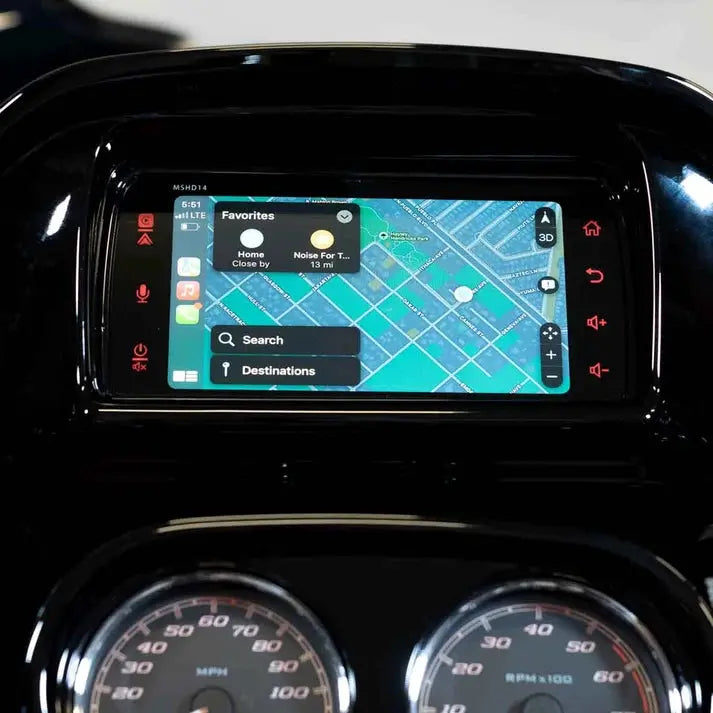 A close-up of the Diamond Audio 2014-2023 Plug N-Play Digital Media Receiver for Harley Davidson® Touring Motorcycles (MSHD14) showcases a vehicle dashboard display with a GPS navigation map, labeled buttons, and search options seamlessly integrated with Apple CarPlay. The speedometer and tachometer appear below the screen, emphasizing the advanced features of this Diamond Audio digital media receiver.