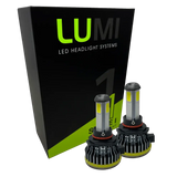 Two LUMI Stage 1 9005 LED Headlight Bulbs are displayed in front of a black and green Lumi LED Headlight Systems box. Featuring silver tops, black bases, and yellow accents, these bulbs are engineered with integrated LED CANBUS technology to deliver a bright 6000K white light for superior visibility.