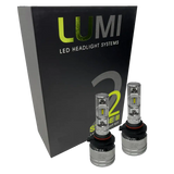 Two Lumi Stage 2 9005 LED Headlight Bulbs with advanced CSP chips are displayed in front of a black box labeled “LUMI LED Headlight Systems 2 Stage II Headlight Kit” on a plain background. Each bulb delivers an impressive 6000 lumens, ensuring bright and efficient illumination.