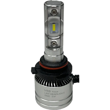 Introducing the LUMI Stage 2 9007 LED Headlight Bulbs by Lumi: Featuring a silver design with integrated cooling fins, a black and red gasket at the base, and visible CSP chips on the front for improved brightness. The bulbs include a black connector attached at the bottom, and “V6S Focus LED HEADLIGHT EMC 21F” printed on the base. These Lumi headlights emit a crisp 6000K white light, delivering superior visibility for nighttime driving.