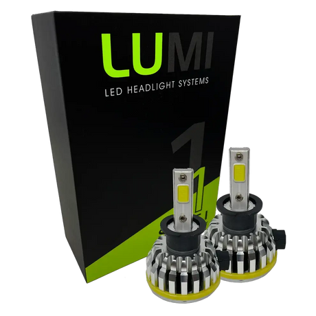 Two LUMI Stage 1 H3 LED headlight bulbs with metallic heatsinks are positioned in front of a black and green Lumi LED Headlight Systems box on a white background, showcasing advanced LED CANBUS compatibility and an impressive 40-watt power output.