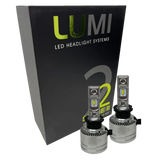 Two premium LUMI Stage 2 H3 LED Headlight Bulbs with advanced CSP chips are positioned in front of a sleek black Lumi LED Headlight Systems box labeled Stage 2, delivering brilliant 6000K color temperature illumination.