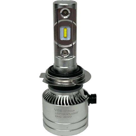 The Lumi LUMI Stage 2 H7 LED Headlight Bulb features high-performance CSP chips and a rectangular yellow diode, housed in a durable silver metal casing with cooling fins and engraved text on the lower section, shown standing upright against a plain white background.