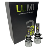 Two LUMI Stage 2 H7 LED Headlight Bulbs from Lumi, featuring advanced CSP chips, are displayed in front of a black box labeled “LUMI LED Headlight Systems S2 Stage II Headlight Kit” on a white background, providing bright 6000K illumination for superior visibility.